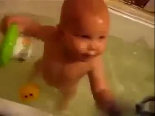 a cute baby showing a swimming trick in bathtub