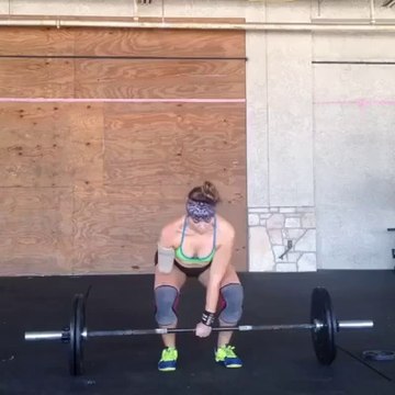 Elle soulève une barre d'haltérophilie avec un seul bras