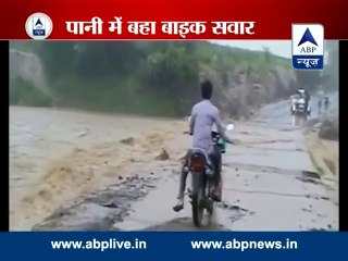 Biker washed away into river while crossing a flooded bridge