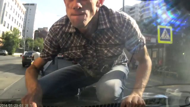 Un fou saute sur une voiture qui roule et se tape la tête sur le pare-brise!