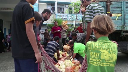 Displaced Palestinians receive relief bread rations