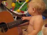 Küçük bebek gitar çalan babasına eşlik ediyor