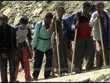 Tired pilgrims walk by holding sticks: Amarnath Yatra