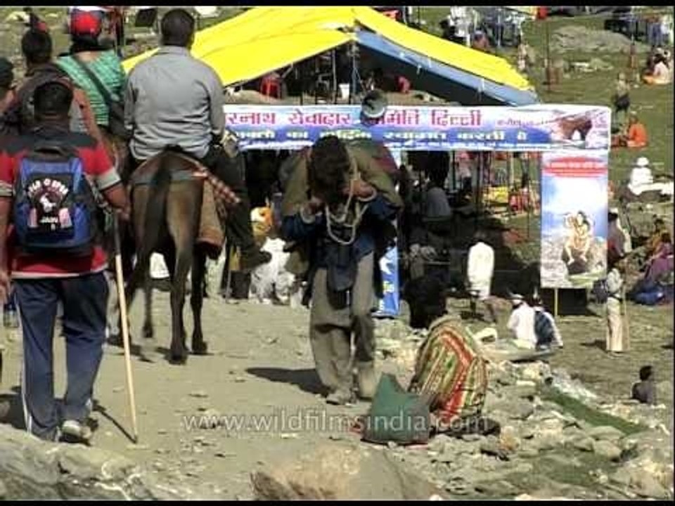 Pilgrims in saffron clothes resting along the way to Amarnath shrine