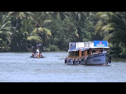Motor boat and traditional race boat sailing on backwaters of Kerala