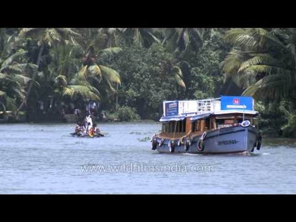 Motor boat and traditional race boat sailing on backwaters of Kerala
