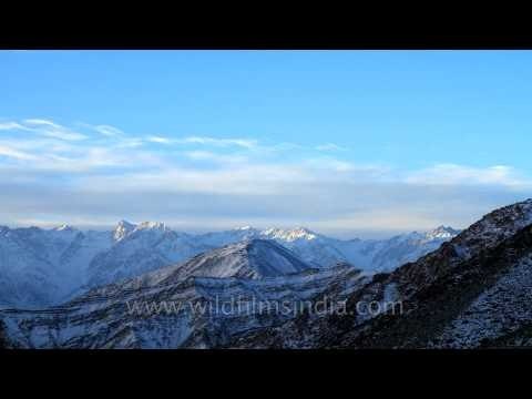 Clouds moving in quick motion over snow covered Himalayan range