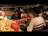 Customers buying onions and potatoes at Kolkata vegetable market
