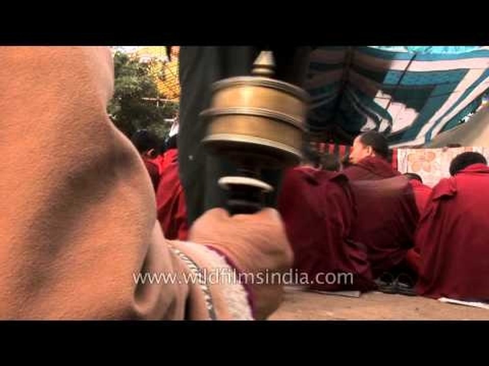 Tibetan worshipper spins a hand-held prayer wheel at Bodhgaya