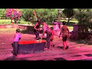 Children wet with coloured water during Holi festival