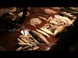 Fish seller puts incense sticks in fish basket after worshipping - Kolkata