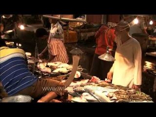 Aged customer bargains with fish seller - Kolkata