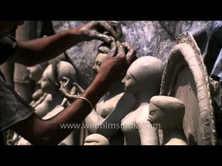 Sculptor working on clay idol - Kumortuli