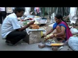 Indian woman sells roasted bhutta/corn in Delhi streets
