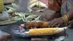Woman bhutta seller roasts corn on live coals in Delhi