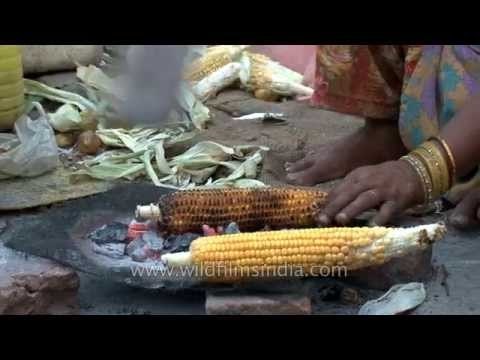 Woman bhutta seller roasts corn on live coals in Delhi