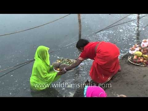 Women perform rituals during Chhath Puja on the banks of River Yamuna