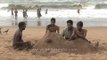 Young boys playing with sand on Puri Beach - Odisha