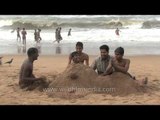 Young boys playing with sand on Puri Beach - Odisha