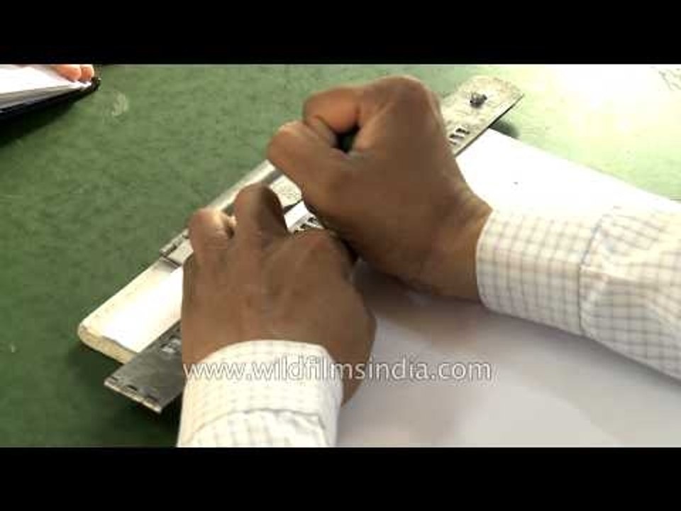 Visually challenged man using slate and stylus for writing in braille