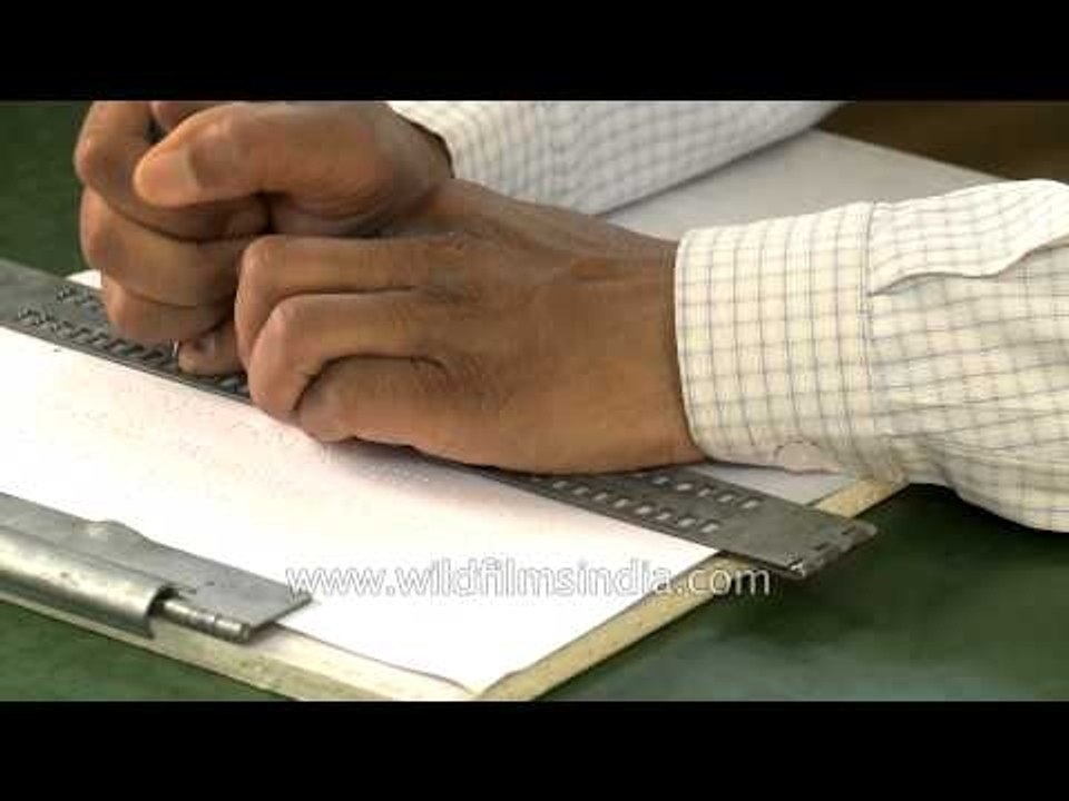 Use of braille slate and stylus by visually challenged man for writing