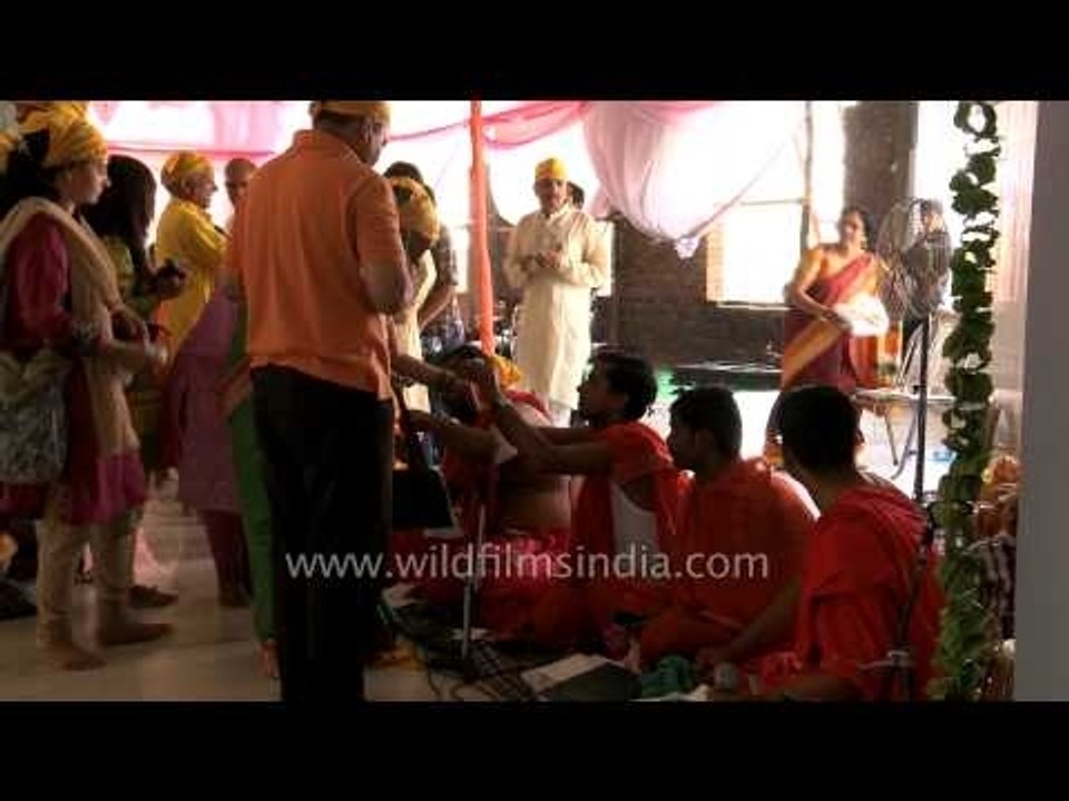Priests tying sacred thread on devotee's wrist