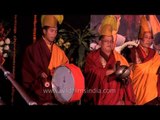 Tibetan monks play traditional instrument at Dilli Haat