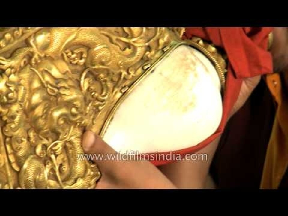 Buddhist monk blowing conch shell at Mindrolling Monastery