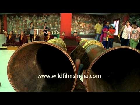 Buddhist monks playing dungchen during evening prayer