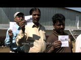 People displaying their voter slips at the voting booth in Lohaghat