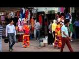 Men dressed as clown drawing people towards the clothing store