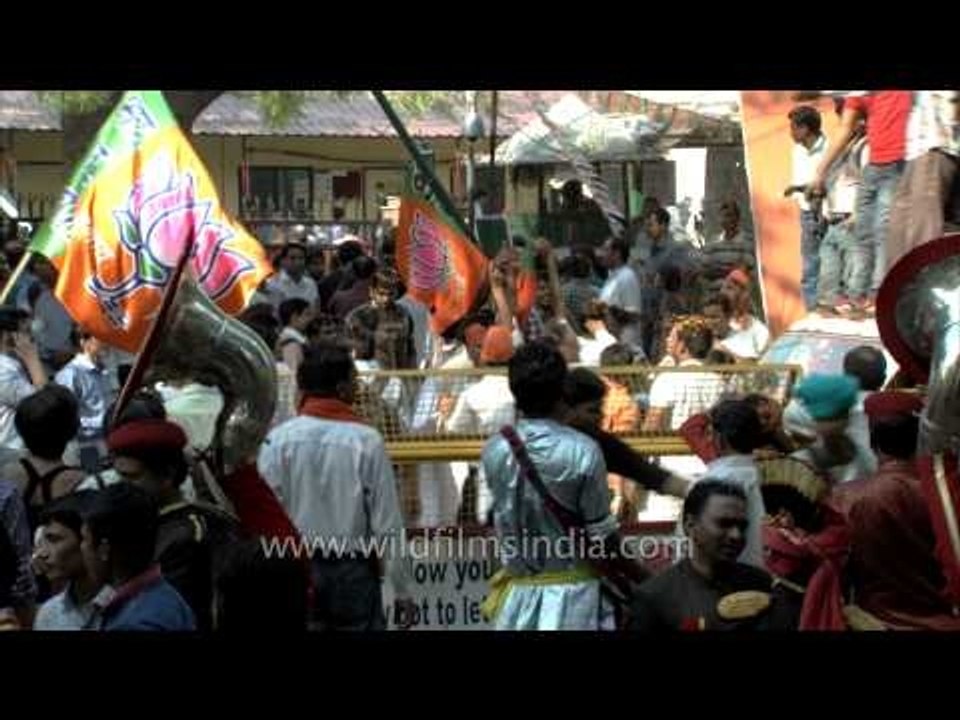 BJP supporters celebrate the party's winning preliminary result outside their office