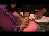 Mehendi artist applying mehendi to groom's hands : Kumaoni Wedding