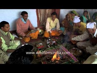 Groom's father offering clothes to priests after 'havan'