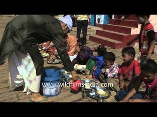 Groom feeding small kids at a Kumaoni wedding in Uttarakhand