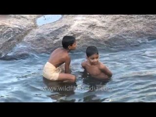 Boys dip into the waters of the river at Thiruvalluvar Temple