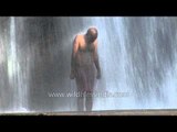 Man bathing in Thiruparappu waterfalls, India