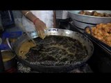 Slow motion: sticking hand into a boiling cauldron of fat and oil!