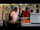Cooking meat skewers in cylindrical ovens at local street kitchen