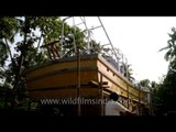 Workers painting large fishing boat in Kochi
