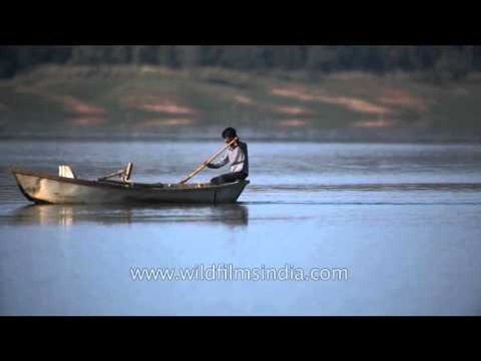 Boy rowing on a wooden boat in Denwa River in Satpura, MP