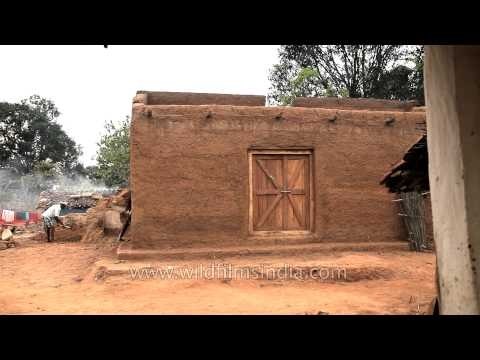 Man constructing a traditional mud house in Narna village