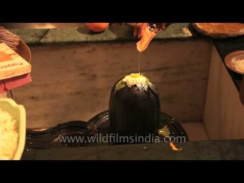 Hindu saint performs purification ritual on Shiv Ling phallus