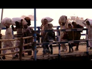 Children search for coins thrown by pilgrims, from murky waters of Bay of Bengal