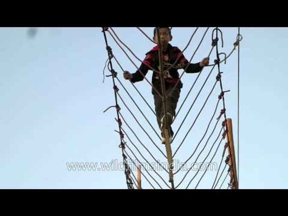 Boys crossing rope bridge at Sangai festival