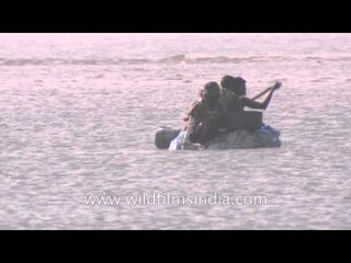 Three men paddling on a recycled inflatable raft boat