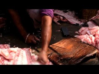 Fish vendor smoothly cutting the fish from big blade