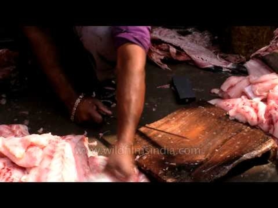 Fish vendor smoothly cutting the fish from big blade