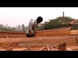 Boat makers polishing the wooden boat