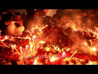Shia Muslims offering garlands, diyas, insences and candles to the grave of Tazia
